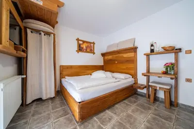 a small bedroom with a bed with white sheets at Hiša vina Cuk in Lendava