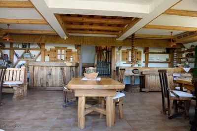 a dining room with a wooden table and chairs at Hiša vina Cuk in Lendava