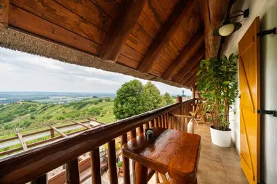 a balcony with a wooden table and a view at Hiša vina Cuk in Lendava