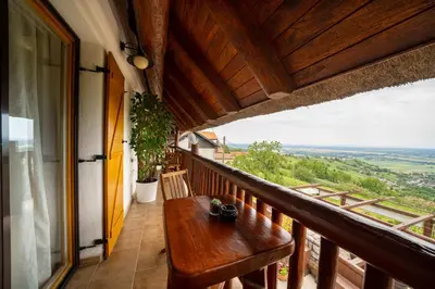a porch with a wooden bench on a balcony at Hiša vina Cuk in Lendava