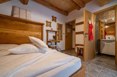 a bedroom with a large bed and a bathroom at Hiša vina Cuk in Lendava