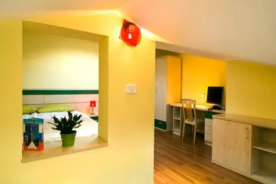 a room with a bed and a kitchen with a desk at Hiša posebne Sorte in Kodreti