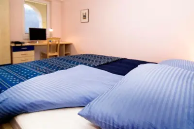 a bedroom with two beds and a desk with a computer at Hiša posebne Sorte in Kodreti
