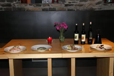 a wooden table with plates of food and bottles of wine at Hiša posebne Sorte in Kodreti