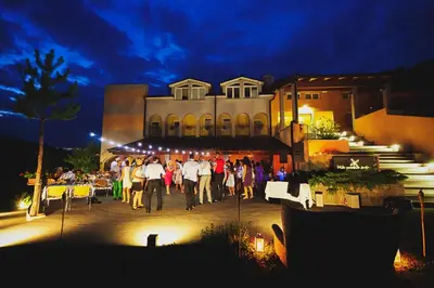 a group of people standing outside of a building at night at Hiša posebne Sorte in Kodreti