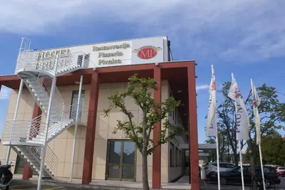 a hotel with a spiral staircase in front of a building at Hotel Prunk in Sežana
