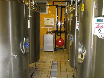 a row of silver tanks in a kitchen with ailed floor at Hotel Prunk in Sežana