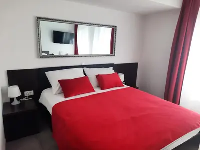 a bedroom with a red bed with a red blanket at Hotel Prunk in Sežana
