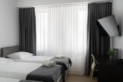 a hotel room with two beds and a desk at Hotel Prunk in Sežana