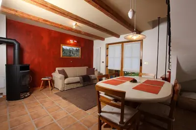 a living room with a table and a stove at Kronau Chalet Resort in Kranjska Gora