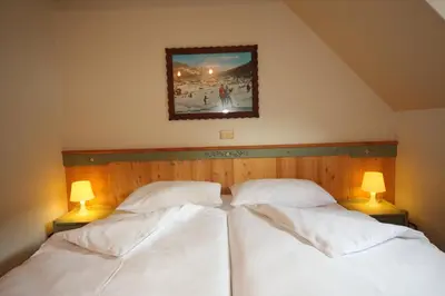 two beds in a bedroom with two lamps at Kronau Chalet Resort in Kranjska Gora
