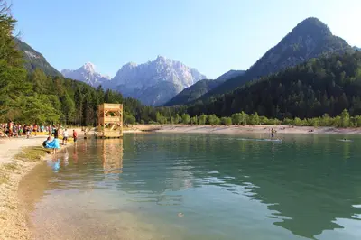 a group of people standing on the shore of a river at Kronau Chalet Resort in Kranjska Gora