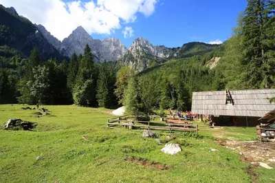 a group of people standing in a field next to a barn at Kronau Chalet Resort in Kranjska Gora