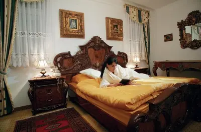 a woman laying on a bed in a bedroom at Hotel Razgorsek in Velenje