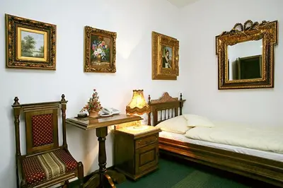 a bedroom with a bed and a desk and a mirror at Hotel Razgorsek in Velenje