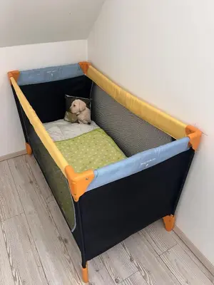 a toy bed with a teddy bear in it at Ana`s place in Celje