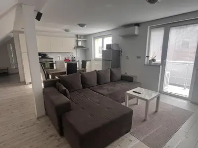 a living room with a brown couch and a table at Ana`s place in Celje
