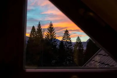 a view of a sunset through a window at B8 apartment in Bohinj