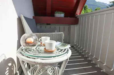 a table on a balcony with cups and plates on it at B8 apartment in Bohinj