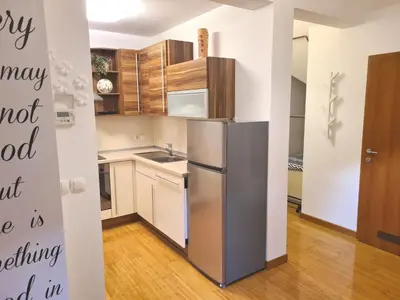 a kitchen with a stainless steel refrigerator and wooden cabinets at B8 apartment in Bohinj