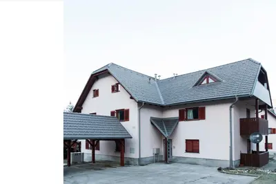 a white building with a black roof at B8 apartment in Bohinj