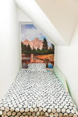 a bed in a room with a painting on the wall at B8 apartment in Bohinj