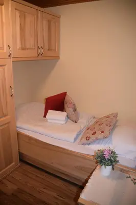 a small bed with white sheets and pillows on it at Farm Stay 