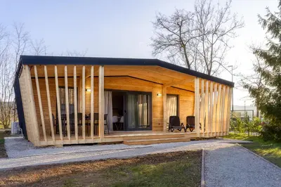 a small wooden house with two chairs in a yard at Pearl of Sava Wild Waters in Ljubljana