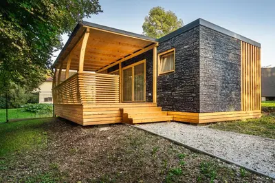 a small house with a black and wooden facade at Pearl of Sava Wild Waters in Ljubljana