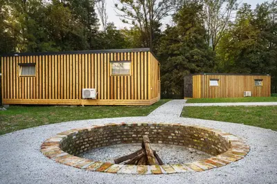 a yellow house with a building in the background at Pearl of Sava Wild Waters in Ljubljana