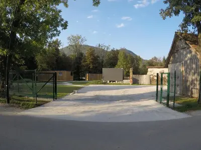 an empty driveway with a fence and a barn at Pearl of Sava Wild Waters in Ljubljana