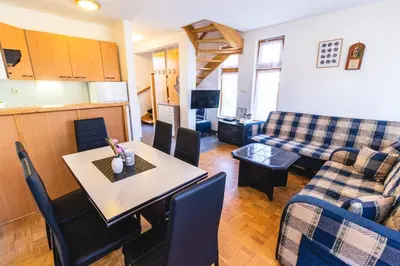 a living room with a table and a couch at POČITNIŠKI APARTMAJI - Extraordinary apartment in Banovci in Veržej