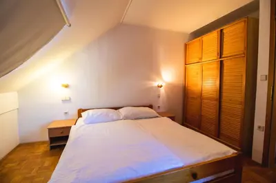 a bedroom with a bed and a wooden door at POČITNIŠKI APARTMAJI - Extraordinary apartment in Banovci in Veržej