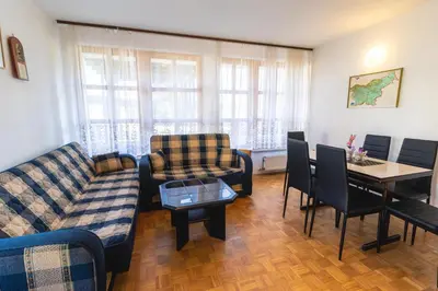 a living room with a couch and a table and chairs at POČITNIŠKI APARTMAJI - Extraordinary apartment in Banovci in Veržej