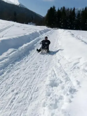 a man riding a snowboard down a snow covered slope at Apartments Tubej in Bohinj