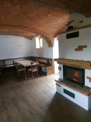 a living room with a fireplace and a table at Apartments Tubej in Bohinj