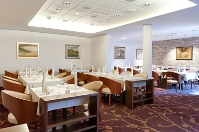 a restaurant with tables and chairs in a room at Terme Zreče – Hotel Atrij in Zreče