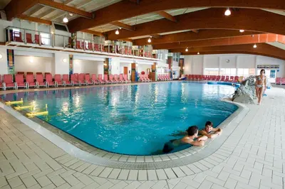 two people swimming in a large swimming pool at Terme Zreče – Hotel Atrij in Zreče