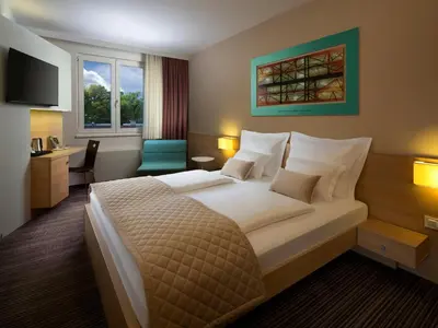 a hotel room with a large bed and a desk at Ahotel Ljubljana in Ljubljana