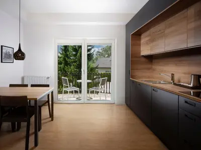 a kitchen with a table and a dining room at Ahotel Ljubljana in Ljubljana