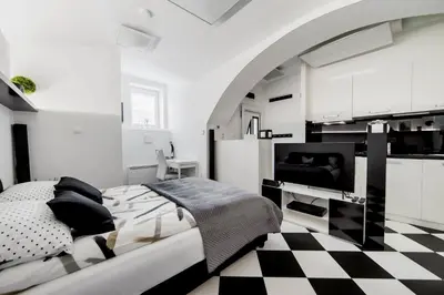 a bedroom with a bed and a checkered floor at Black and White Studio in Ljubljana