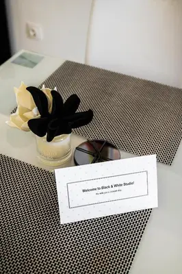 a table with a bowl of flowers and a note at Black and White Studio in Ljubljana