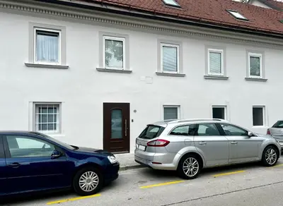 two cars parked in a parking lot in front of a building at Black and White Studio in Ljubljana