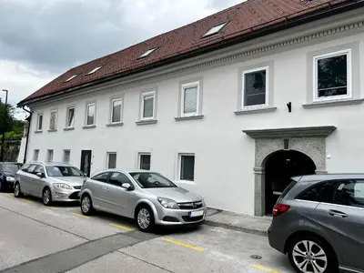 three cars parked in front of a white building at Black and White Studio in Ljubljana