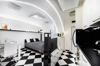 a bedroom with a bed and a checkered floor at Black and White Studio in Ljubljana