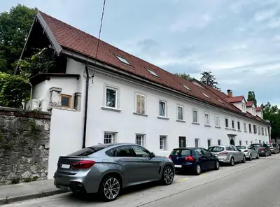 a gray car parked in front of a white building at Black and White Studio in Ljubljana