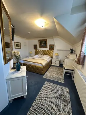 a bedroom with a king sized bed and two tables at Hotel Grande in Celje