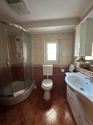 a bathroom with a toilet and a tub and a sink at Hotel Grande in Celje