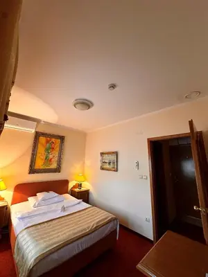 a hotel room with a bed and two lamps at Hotel Grande in Celje