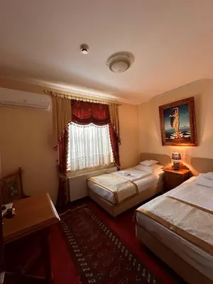 a hotel room with two beds and a window at Hotel Grande in Celje